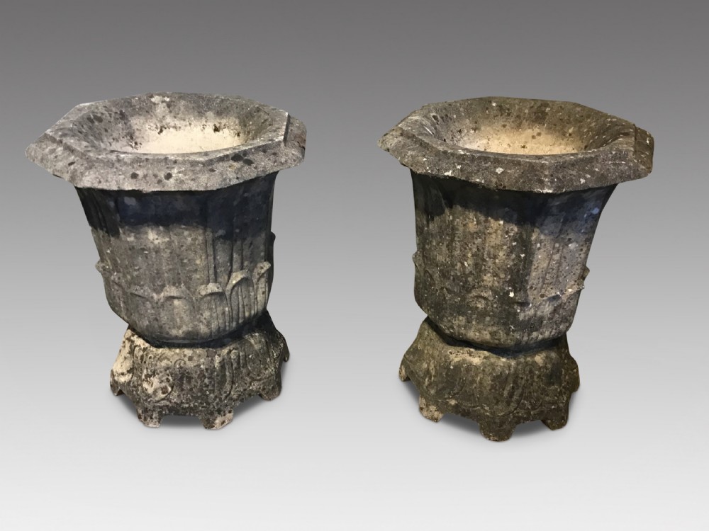 A pair of weathered grey cast stone garden urns with fluted rims and decorative pedestals displaying natural moss and lichen growth. View II