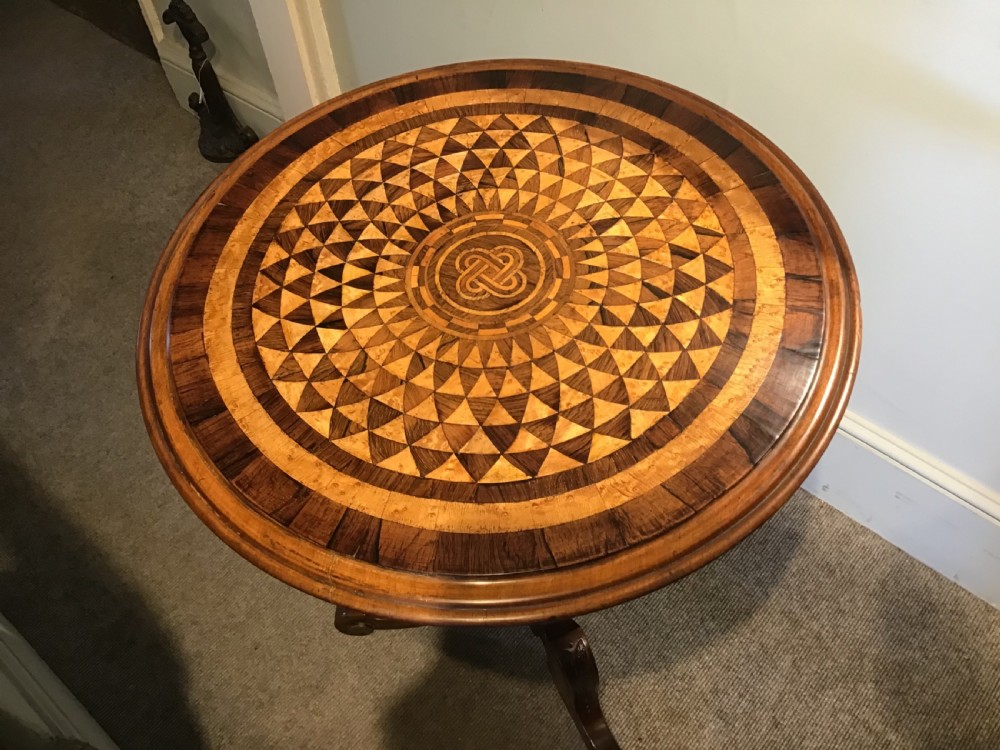 A Victorian tripod occasional table with a circular top featuring geometric specimen wood marquetry and a turned pedestal column. View II