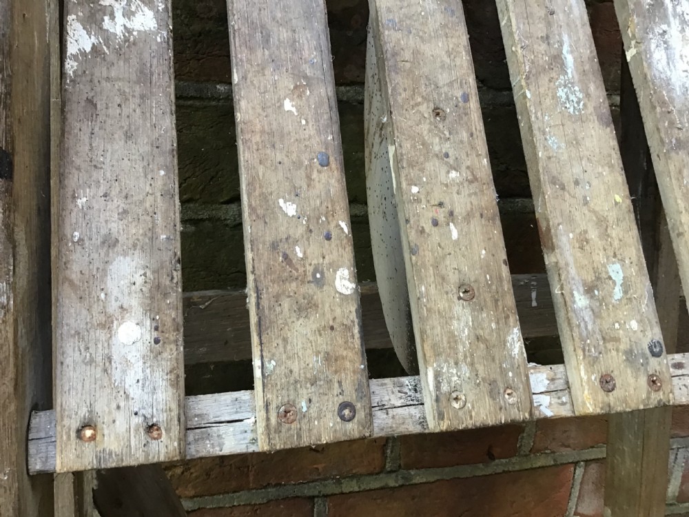 A tall weathered wooden A-frame stepladder featuring a slatted top platform and multiple flat treads. View VII