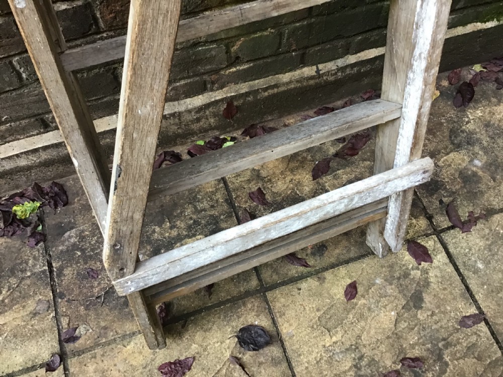 A tall weathered wooden A-frame stepladder featuring a slatted top platform and multiple flat treads. View VIII