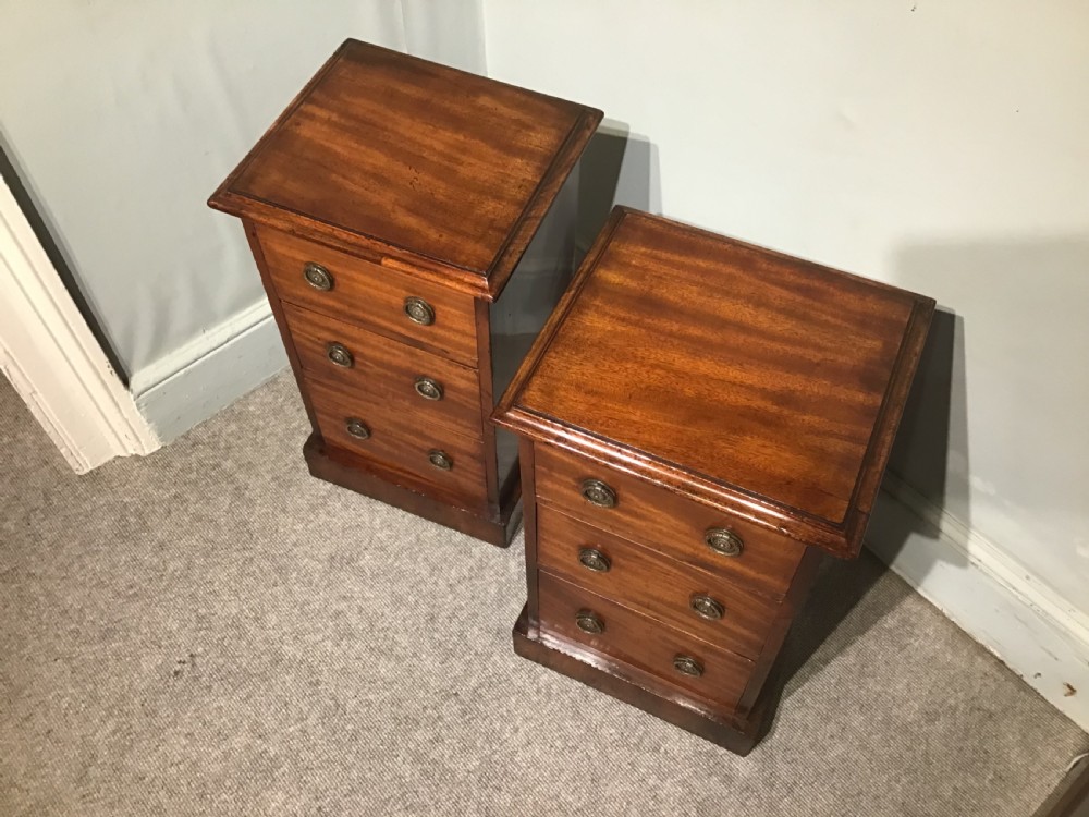 A pair of narrow antique mahogany bedside chests, each featuring three drawers with round brass ring handles and a plinth base. View III