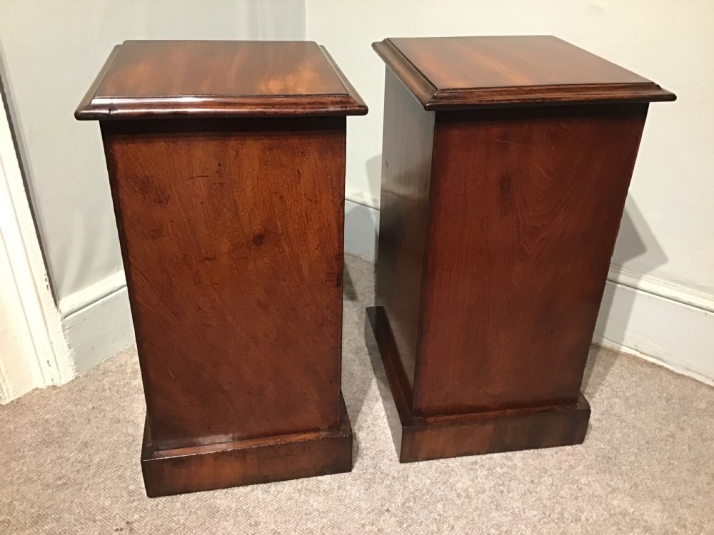 A pair of narrow antique mahogany bedside chests, each featuring three drawers with round brass ring handles and a plinth base. View VII