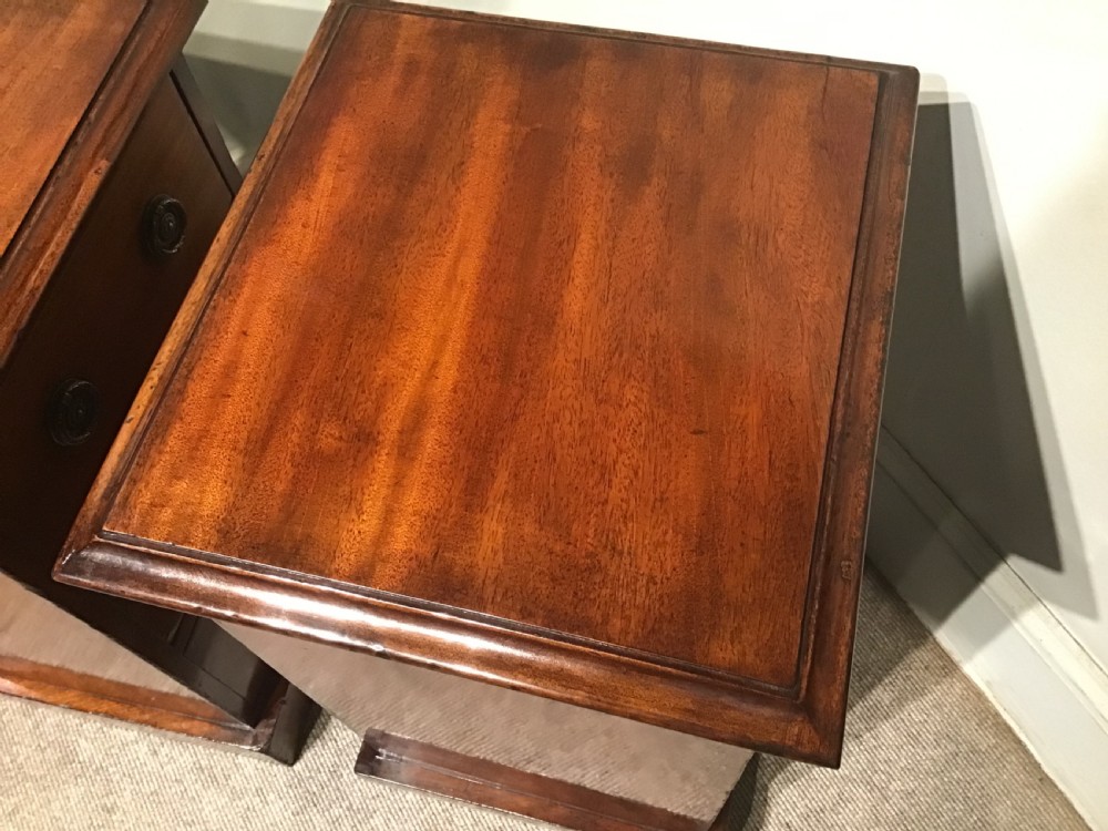 A pair of narrow antique mahogany bedside chests, each featuring three drawers with round brass ring handles and a plinth base. View VIII