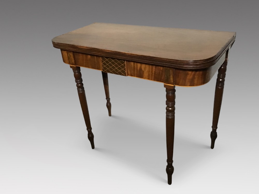 An antique dark mahogany fold-over tea table featuring turned legs and a central inlaid geometric motif on the front apron. View II