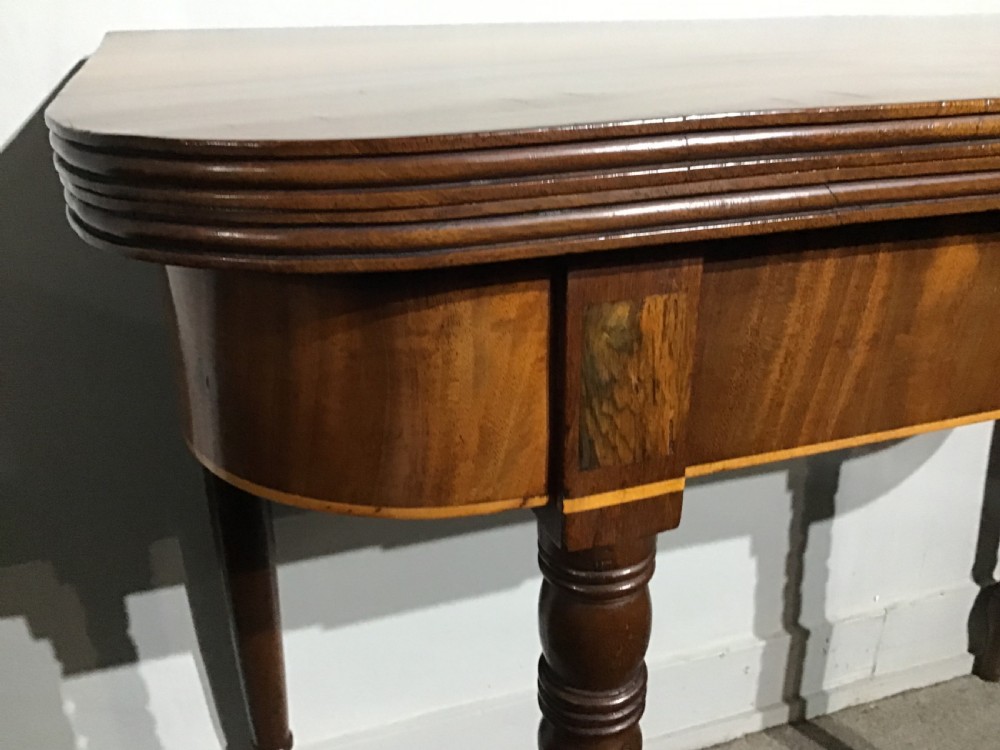 An antique dark mahogany fold-over tea table featuring turned legs and a central inlaid geometric motif on the front apron. View V