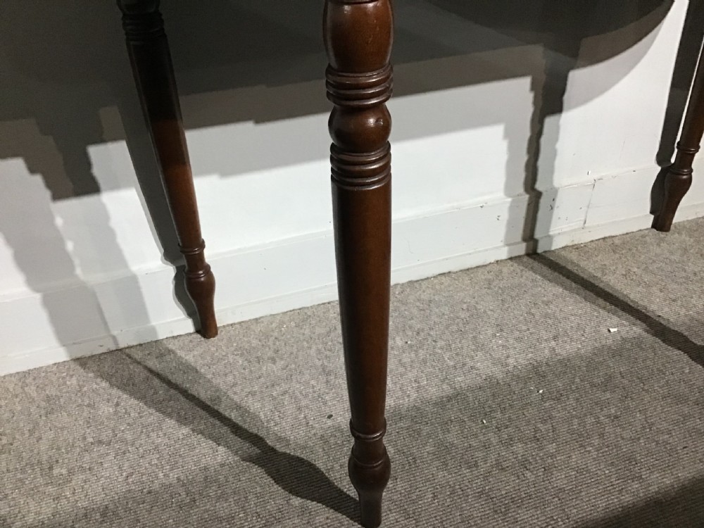 An antique dark mahogany fold-over tea table featuring turned legs and a central inlaid geometric motif on the front apron. View VI