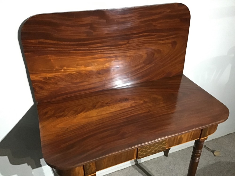 An antique dark mahogany fold-over tea table featuring turned legs and a central inlaid geometric motif on the front apron. View VII