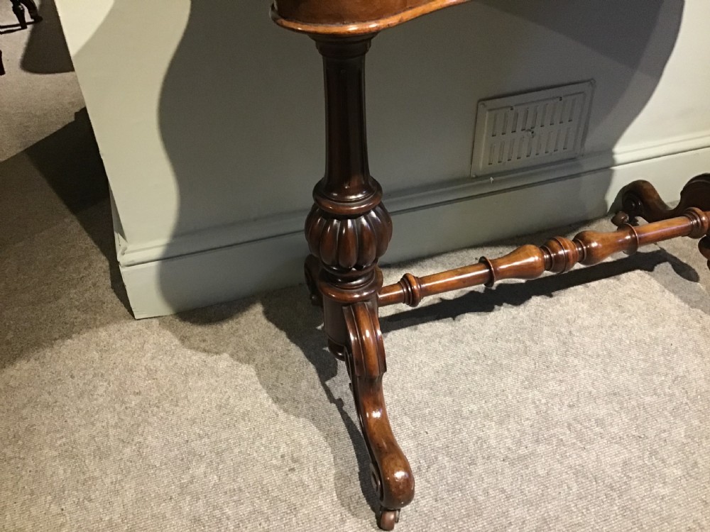 A Victorian mahogany side table featuring a serpentine-shaped top supported by carved baluster pedestals and a turned stretcher. View III