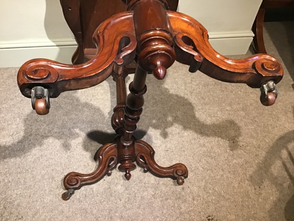 A Victorian mahogany side table featuring a serpentine-shaped top supported by carved baluster pedestals and a turned stretcher. View VIII