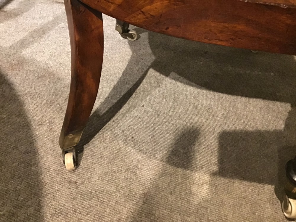 A Regency mahogany bergere armchair featuring hand-woven cane panels, reeded turned front legs on brass castors, and a buttoned green velvet seat cushion. View XII