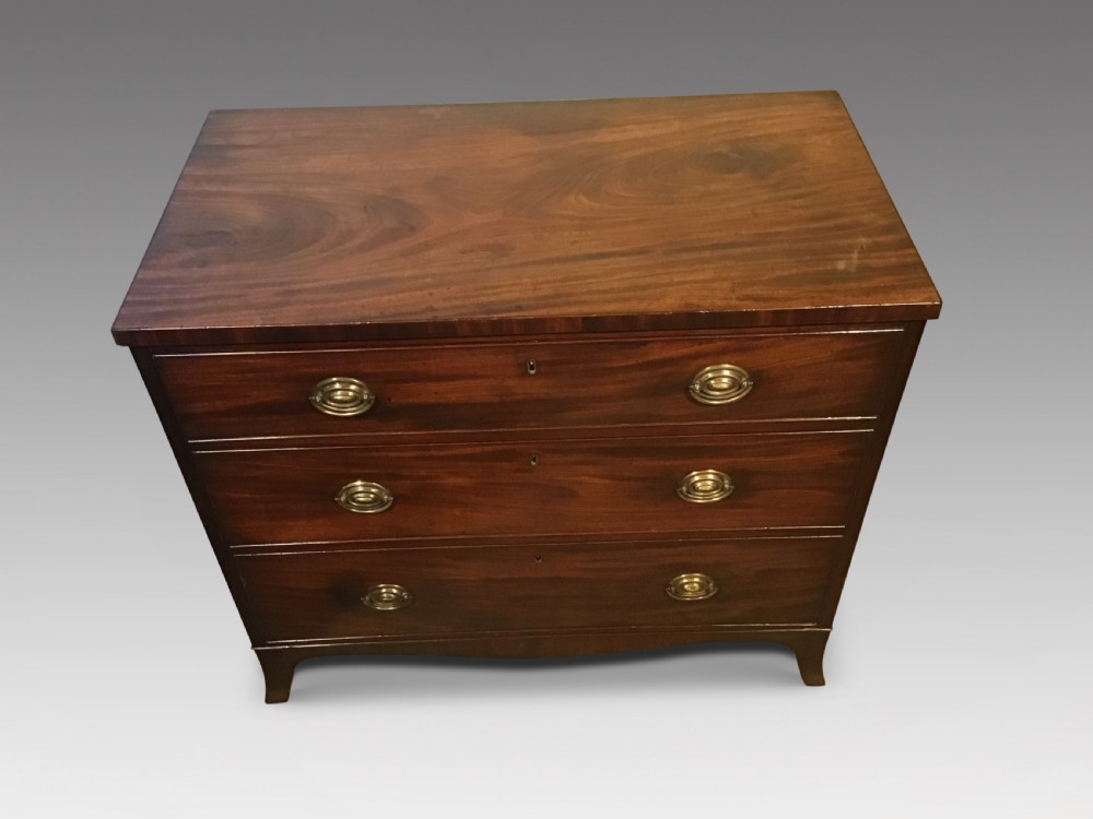 An antique mahogany chest of drawers featuring three drawers with brass oval handles and bracket feet. View II