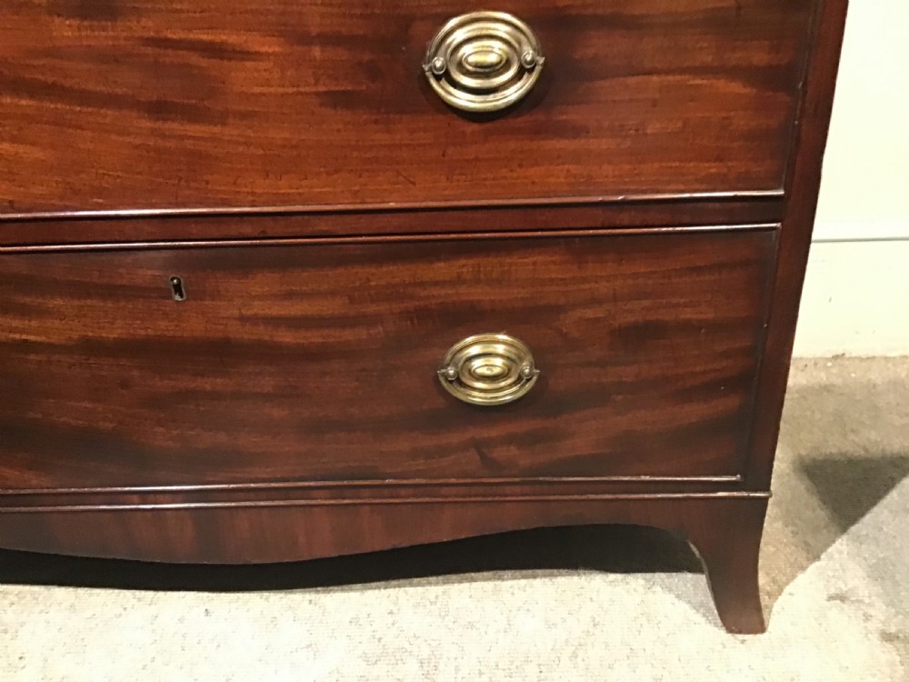 An antique mahogany chest of drawers featuring three drawers with brass oval handles and bracket feet. View III