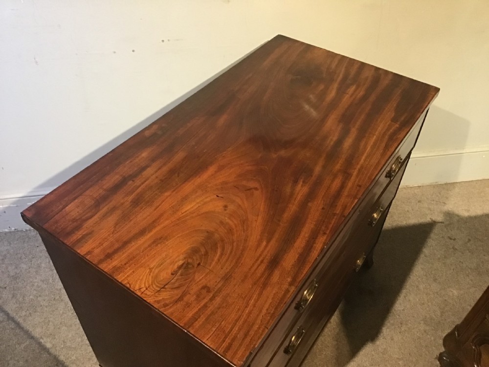 An antique mahogany chest of drawers featuring three drawers with brass oval handles and bracket feet. View VII