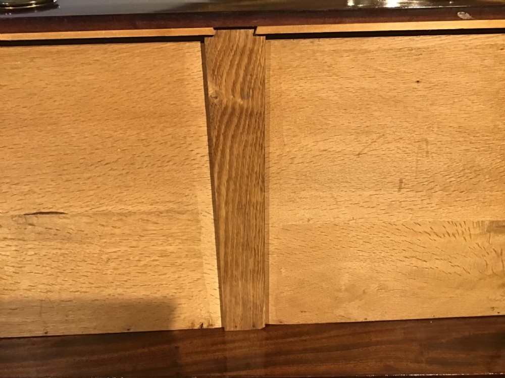 An antique mahogany chest of drawers featuring three drawers with brass oval handles and bracket feet. View XII