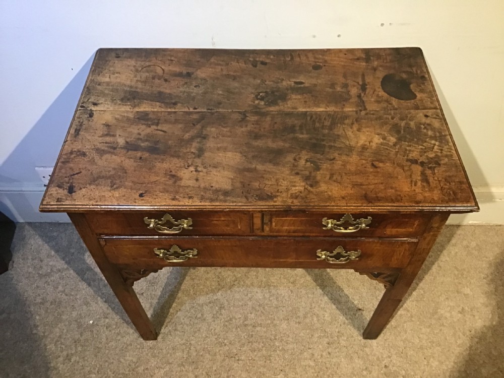 An 18th-century style antique walnut lowboy table featuring three drawers with decorative brass handles and fretwork corner brackets. View II