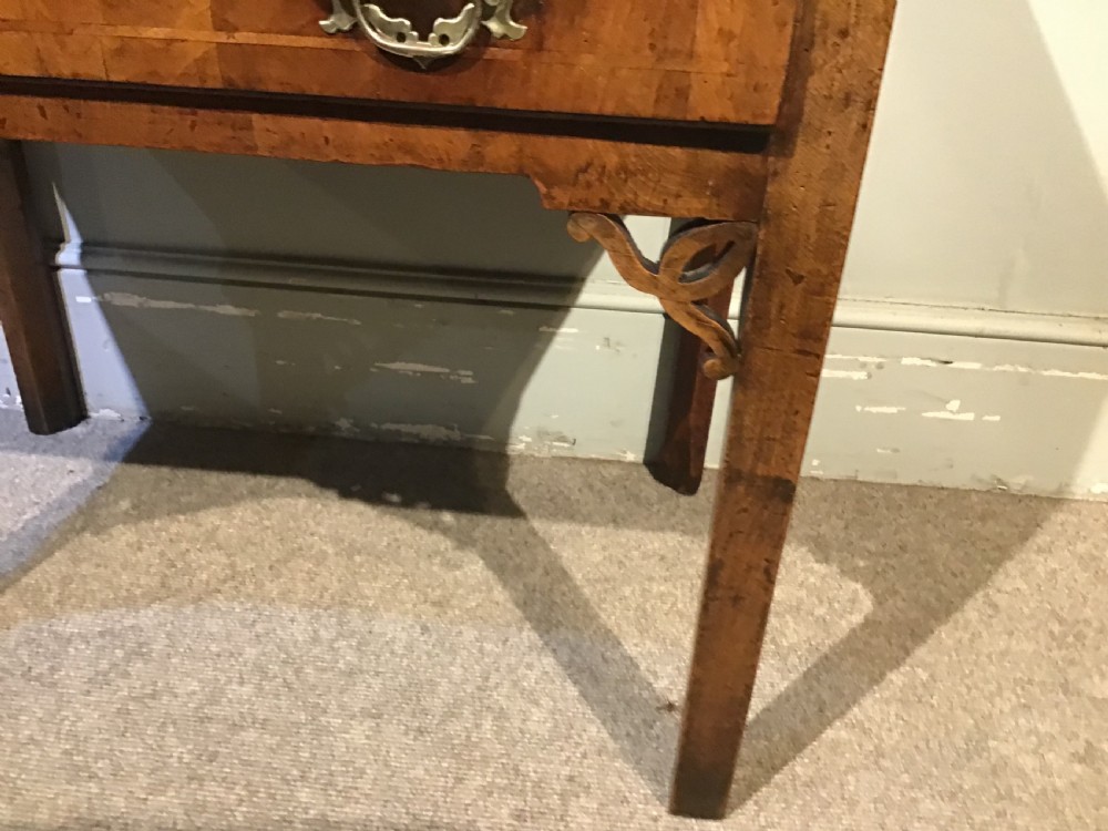 An 18th-century style antique walnut lowboy table featuring three drawers with decorative brass handles and fretwork corner brackets. View V