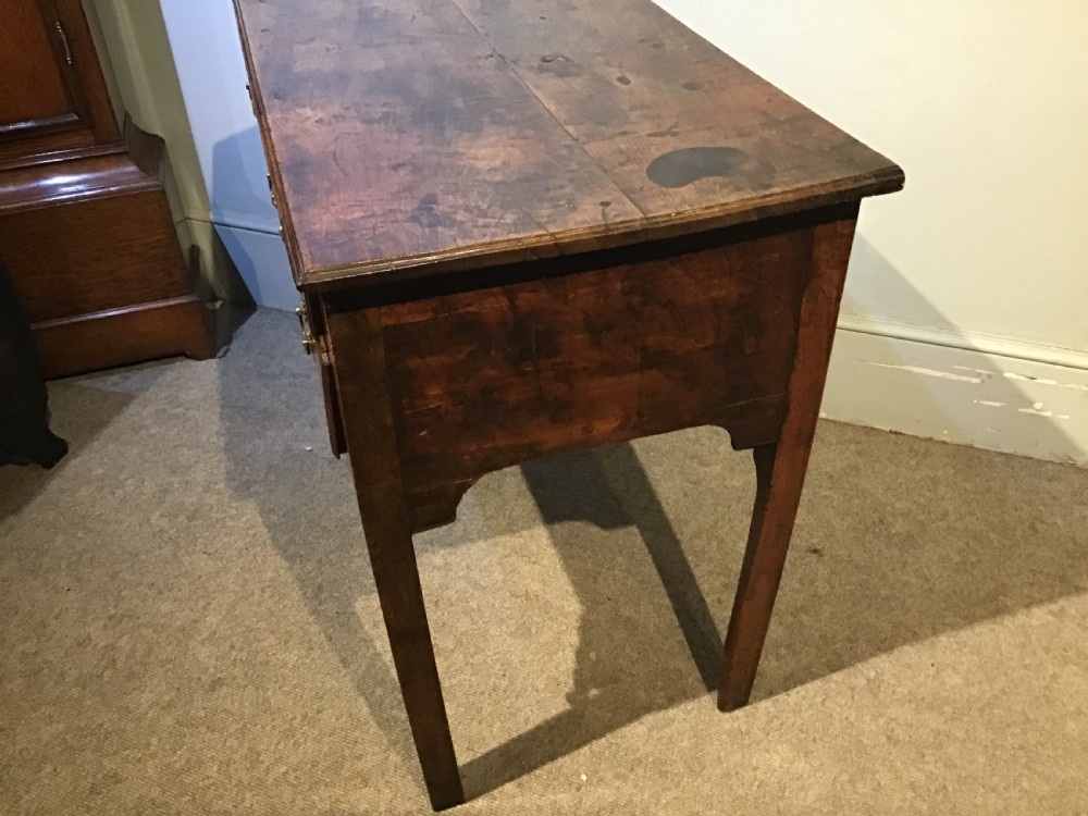 An 18th-century style antique walnut lowboy table featuring three drawers with decorative brass handles and fretwork corner brackets. View VII