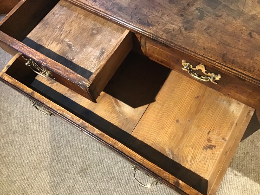 An 18th-century style antique walnut lowboy table featuring three drawers with decorative brass handles and fretwork corner brackets. View XI