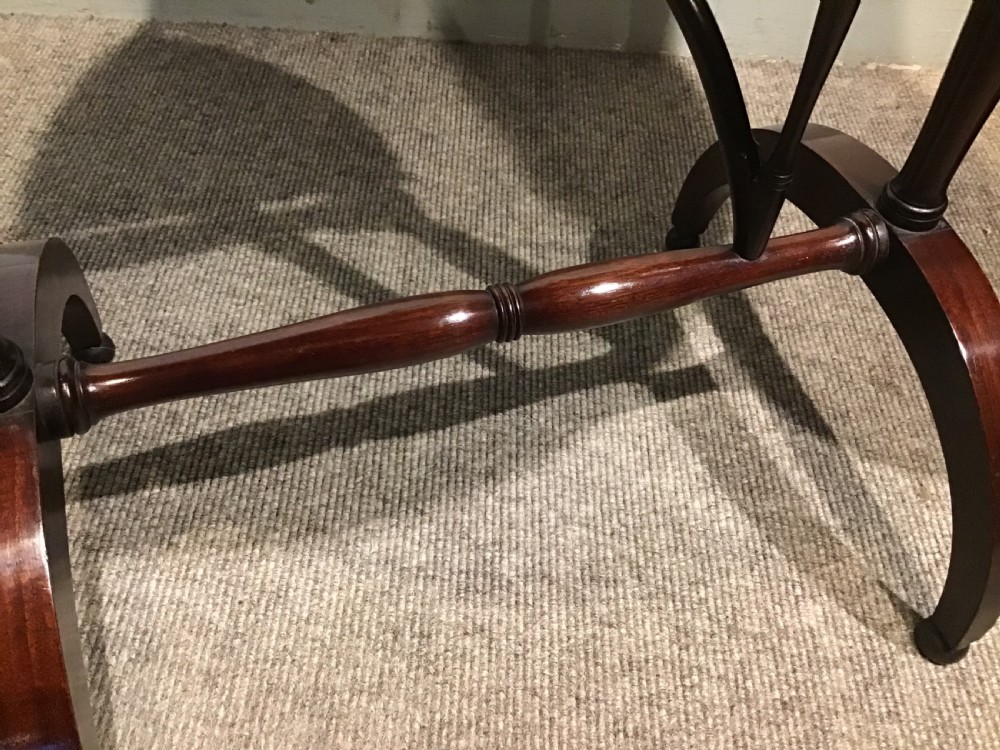 An antique dark mahogany folding occasional table featuring a round top, lower semi-circular shelf, turned uprights, and curved feet. View IX