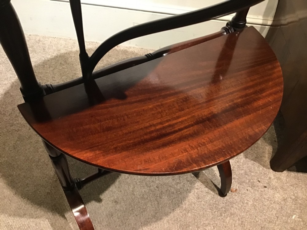 An antique dark mahogany folding occasional table featuring a round top, lower semi-circular shelf, turned uprights, and curved feet. View XVI