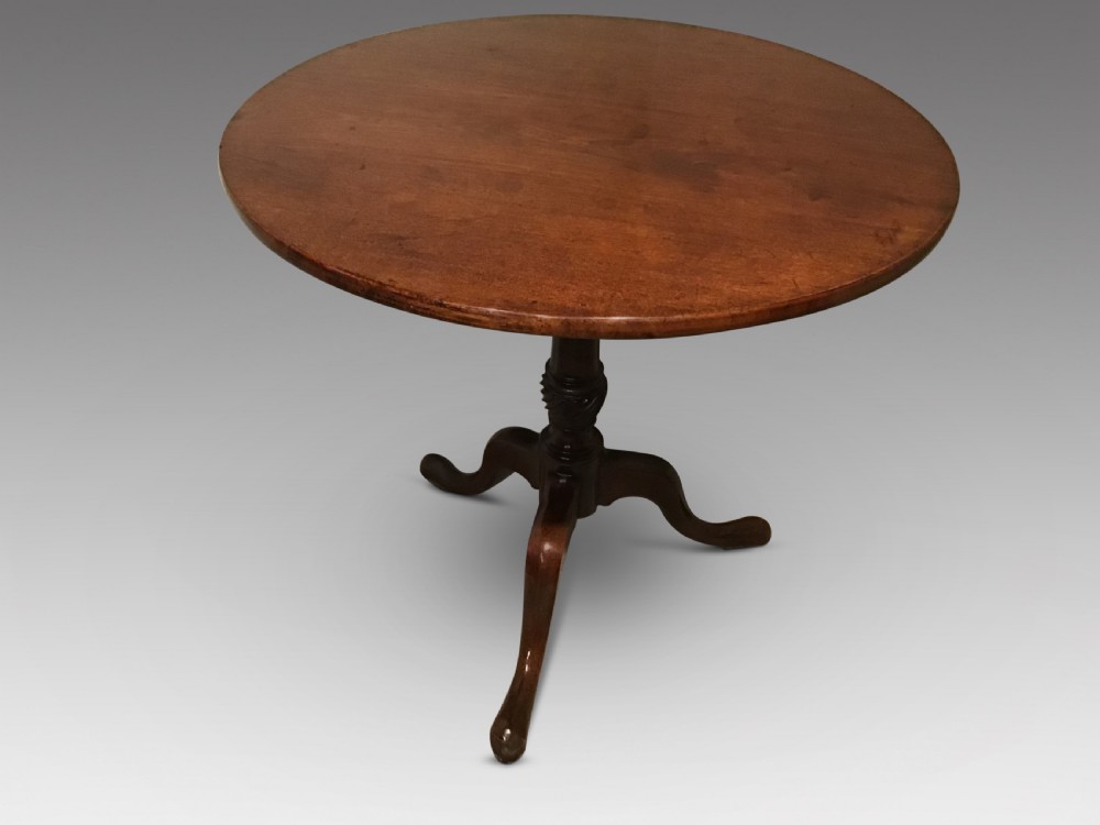A Georgian mahogany tripod table featuring a smooth circular top supported by a turned central pedestal and three cabriole legs.