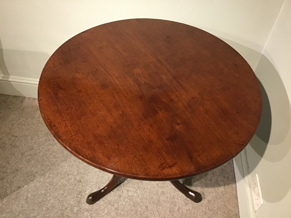 A Georgian mahogany tripod table featuring a smooth circular top supported by a turned central pedestal and three cabriole legs. View III