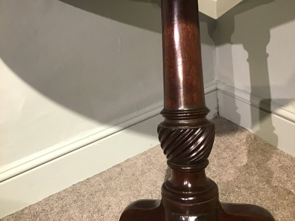 A Georgian mahogany tripod table featuring a smooth circular top supported by a turned central pedestal and three cabriole legs. View VII