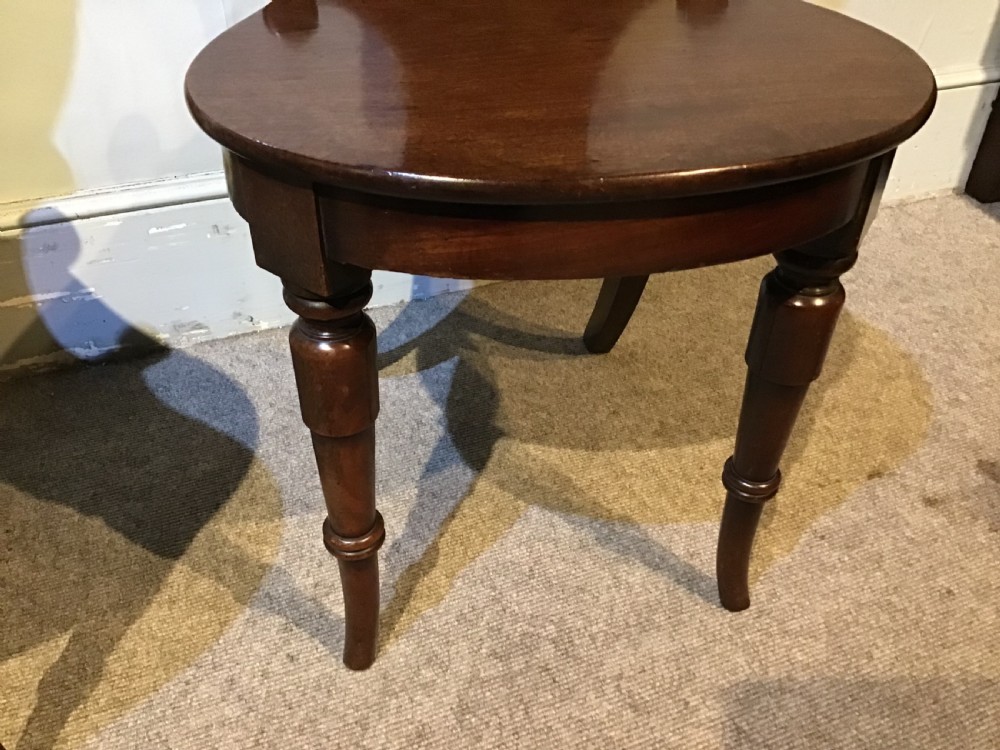 A pair of antique dark mahogany hall chairs featuring carved scroll backs, solid wood seats, and turned front legs. View VIII