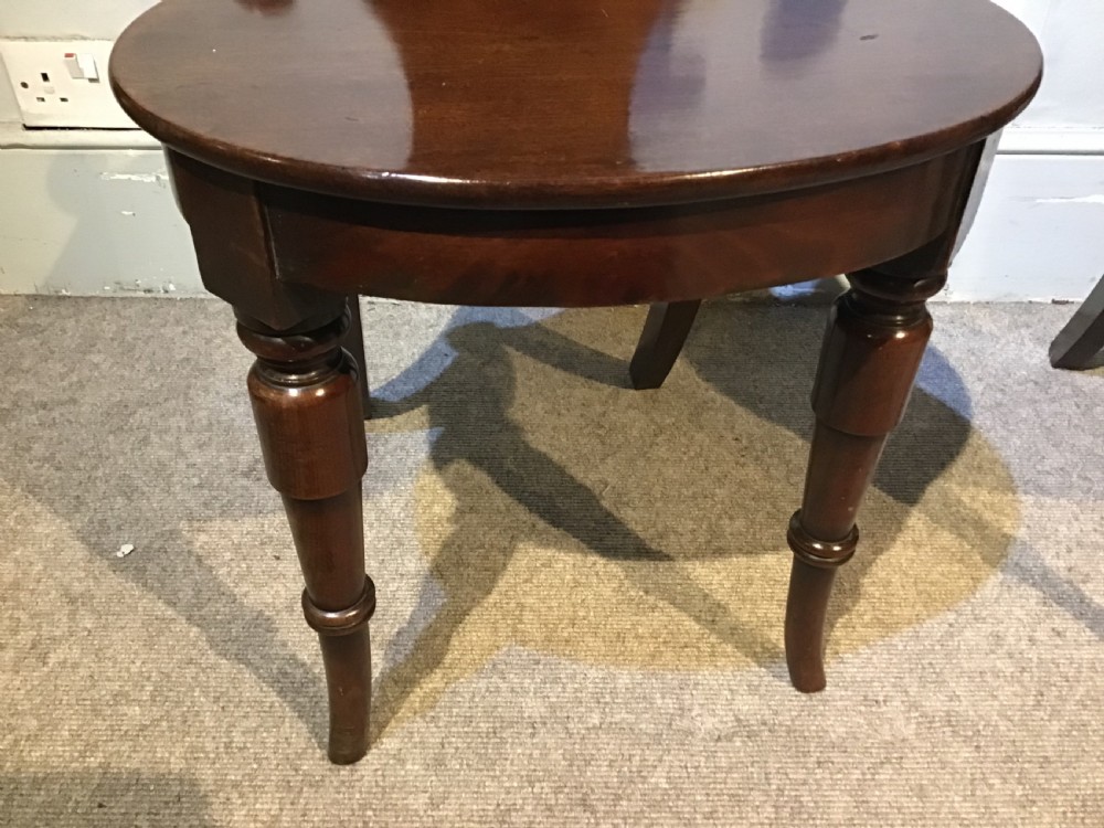 A pair of antique dark mahogany hall chairs featuring carved scroll backs, solid wood seats, and turned front legs. View IX