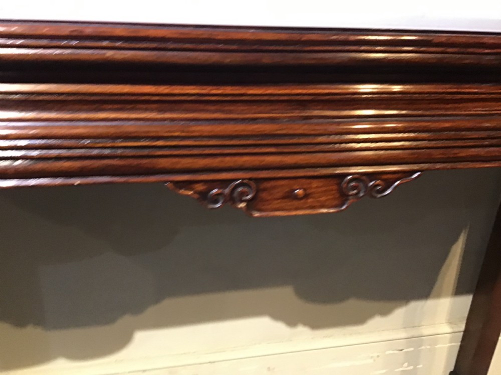 A narrow dark brown timber Chinese altar table featuring carved corner spandrels, reeded square legs, and a rectangular panelled top. View VII