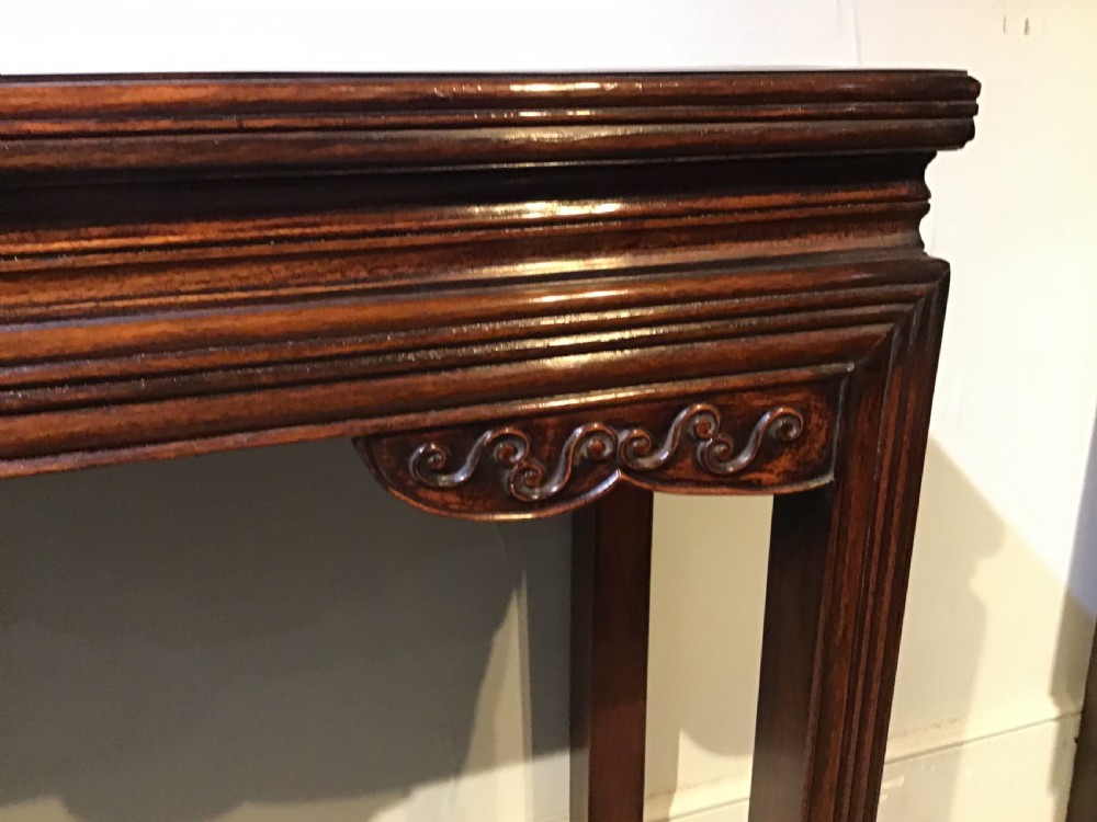 A narrow dark brown timber Chinese altar table featuring carved corner spandrels, reeded square legs, and a rectangular panelled top. View VIII