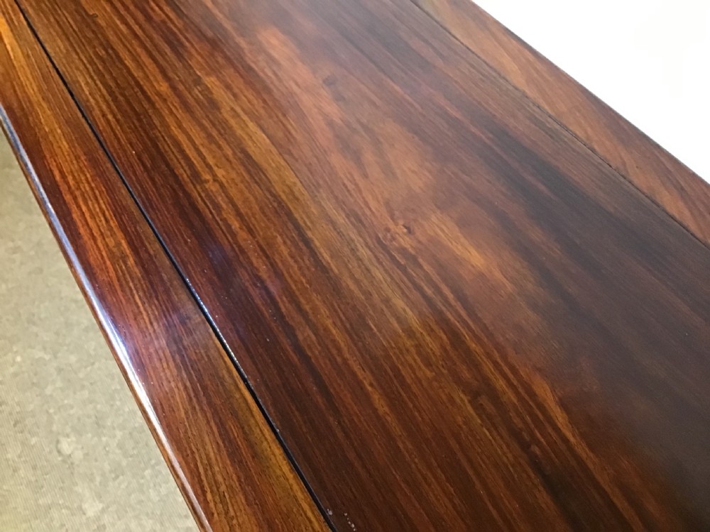 A narrow dark brown timber Chinese altar table featuring carved corner spandrels, reeded square legs, and a rectangular panelled top. View IX