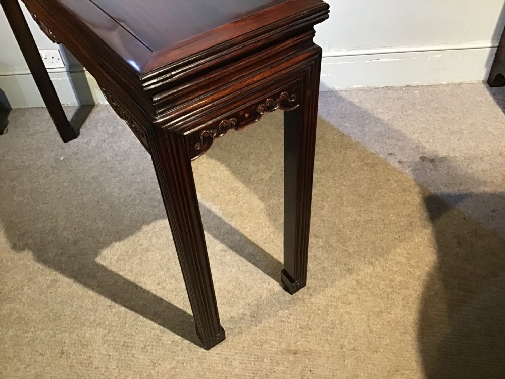 A narrow dark brown timber Chinese altar table featuring carved corner spandrels, reeded square legs, and a rectangular panelled top. View XI
