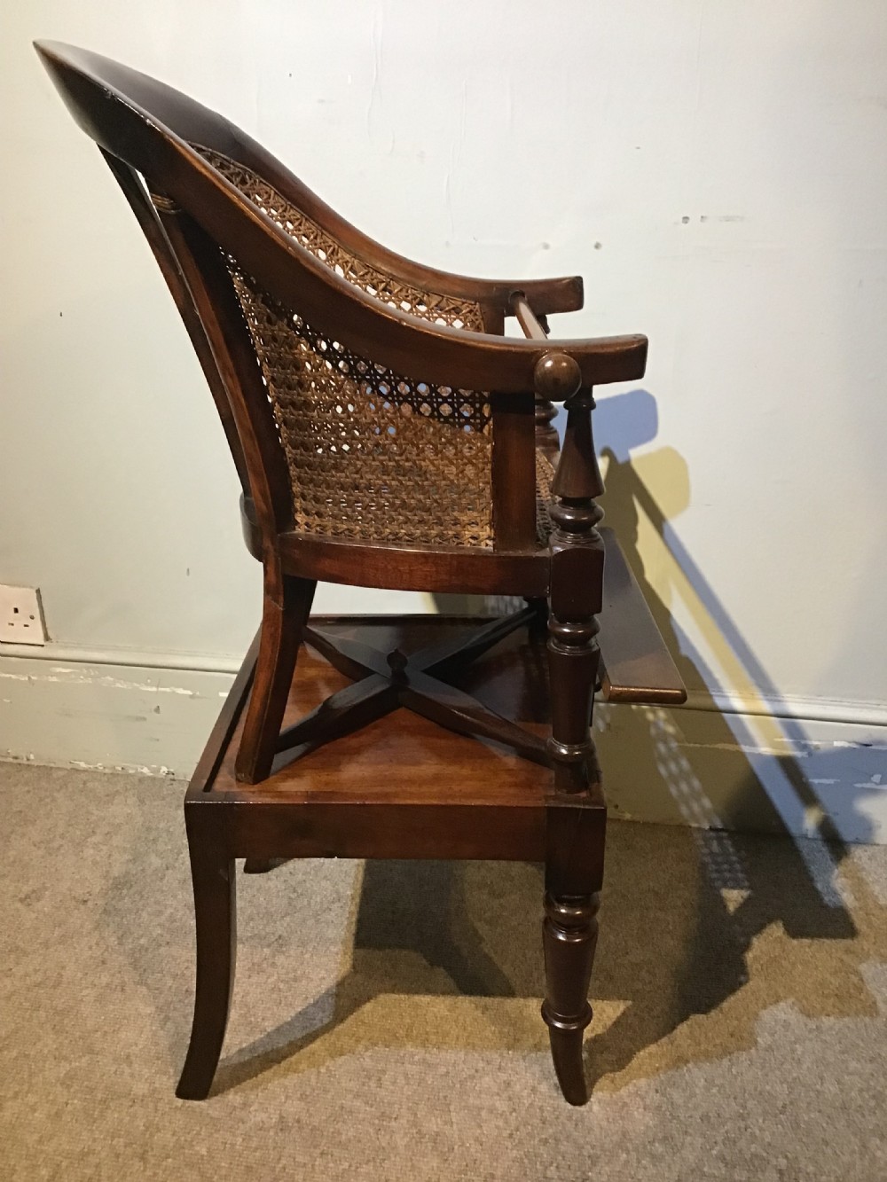 A dark wood Victorian child high chair featuring a woven cane seat and backrest, turned legs, and an integrated wooden footrest. View IV