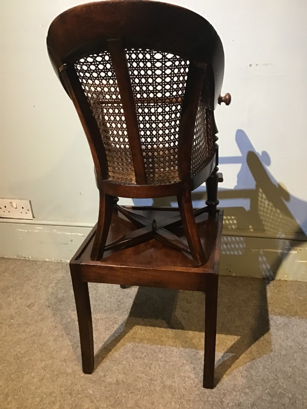 A dark wood Victorian child high chair featuring a woven cane seat and backrest, turned legs, and an integrated wooden footrest. View VI