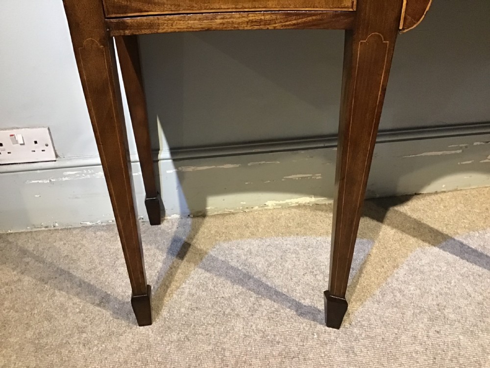 A Georgian style mahogany sideboard featuring a serpentine front, inlaid oval motifs on tapered legs, and brass handles. View VII