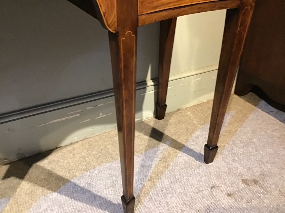 A Georgian style mahogany sideboard featuring a serpentine front, inlaid oval motifs on tapered legs, and brass handles. View IX