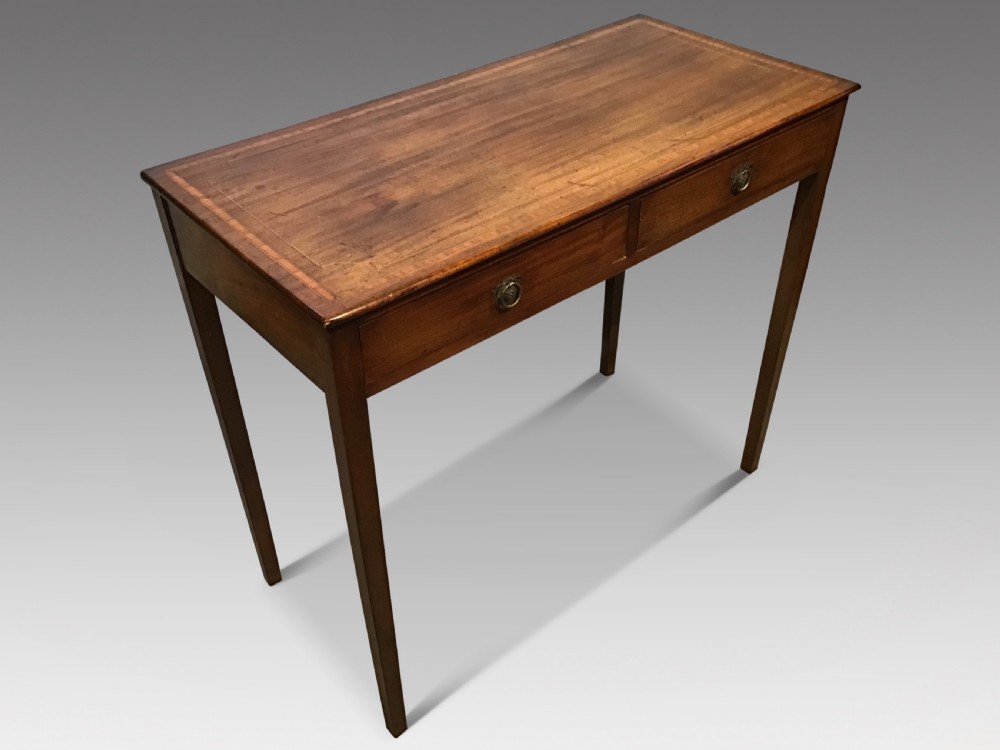 An antique Georgian mahogany side table featuring two drawer compartments with brass ring handles, boxwood inlaid border detail, and four square tapered legs. View II