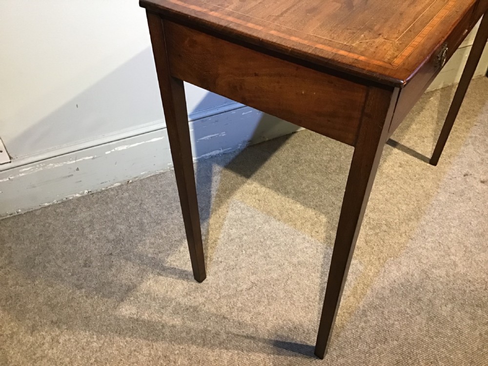 An antique Georgian mahogany side table featuring two drawer compartments with brass ring handles, boxwood inlaid border detail, and four square tapered legs. View III