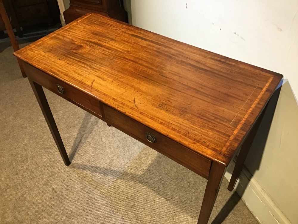 An antique Georgian mahogany side table featuring two drawer compartments with brass ring handles, boxwood inlaid border detail, and four square tapered legs. View VI