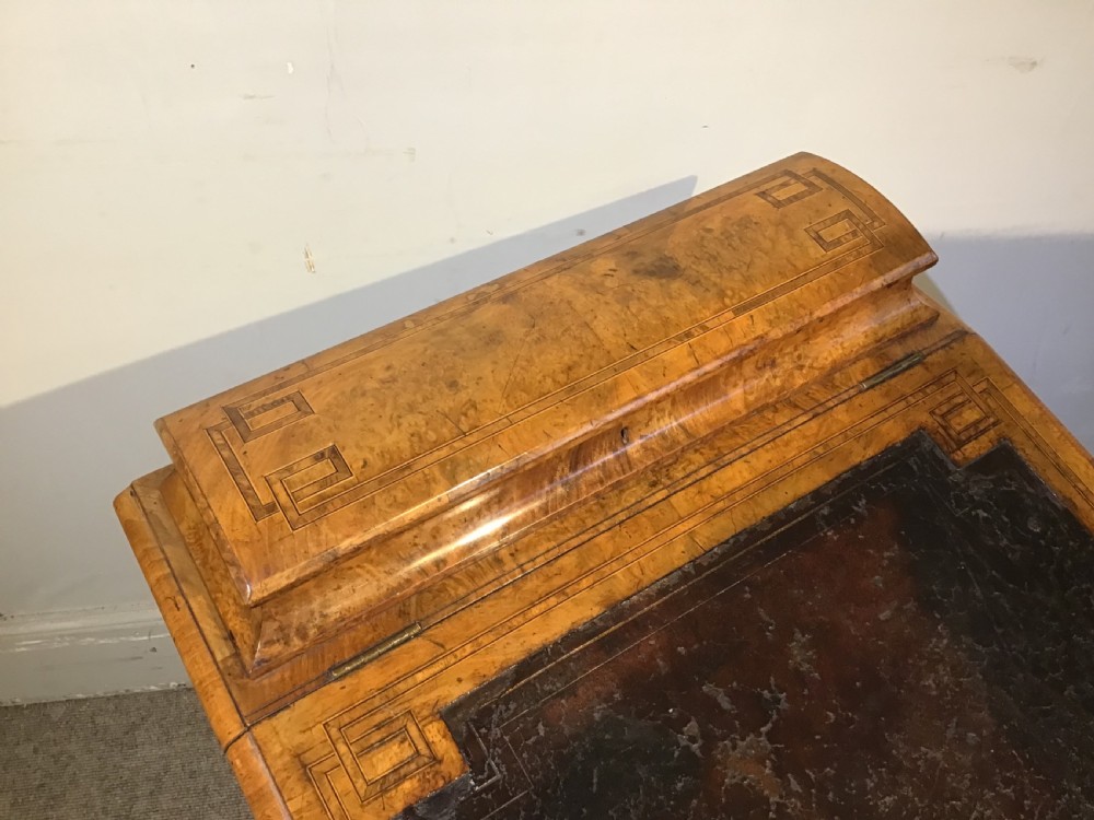 A Victorian burr walnut Davenport desk featuring a sloped leather writing surface, inlaid wood corner detailing, turned front supports, and a top stationery compartment. View III