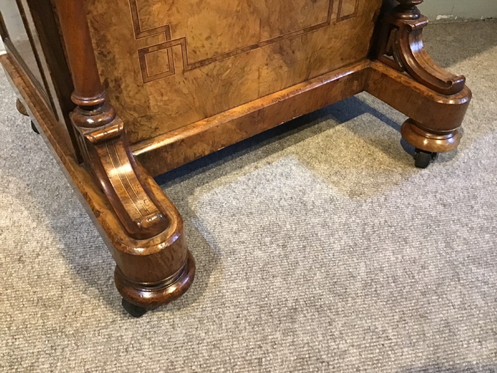 A Victorian burr walnut Davenport desk featuring a sloped leather writing surface, inlaid wood corner detailing, turned front supports, and a top stationery compartment. View IX
