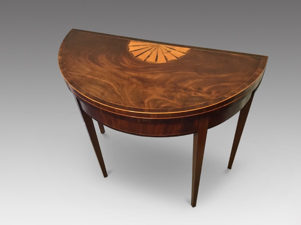 A Georgian dark mahogany demi-lune console table featuring a semicircular top with a central fan inlay motif and square tapered legs. View II