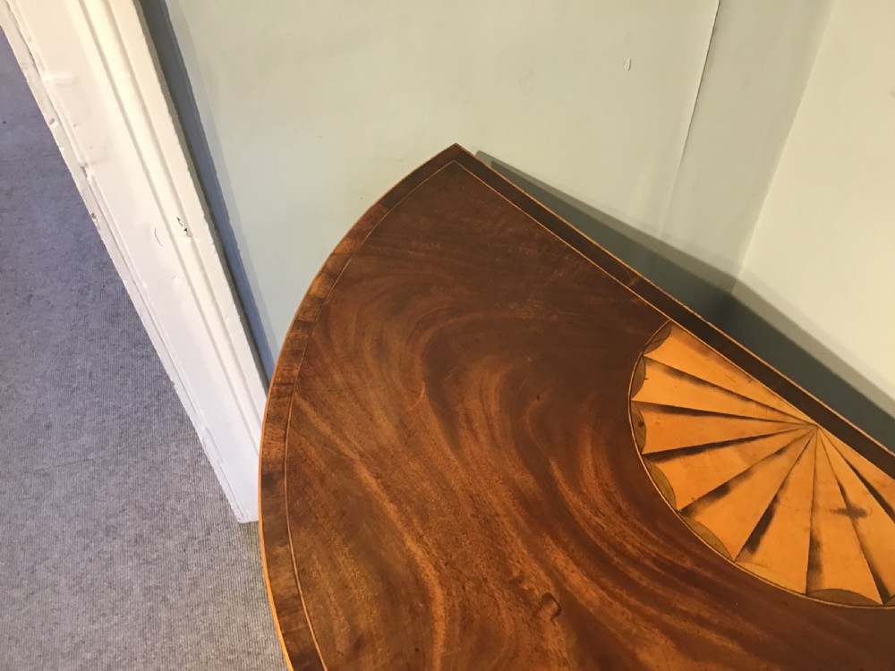 A Georgian dark mahogany demi-lune console table featuring a semicircular top with a central fan inlay motif and square tapered legs. View III