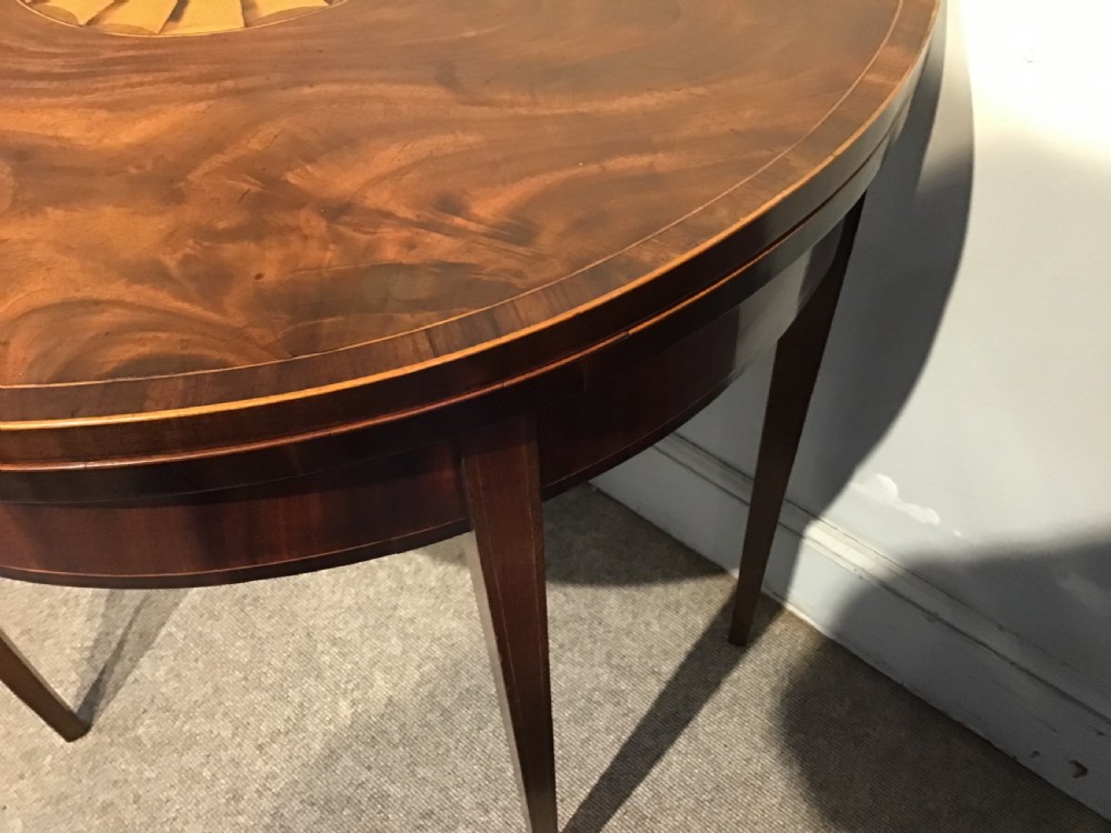 A Georgian dark mahogany demi-lune console table featuring a semicircular top with a central fan inlay motif and square tapered legs. View VIII