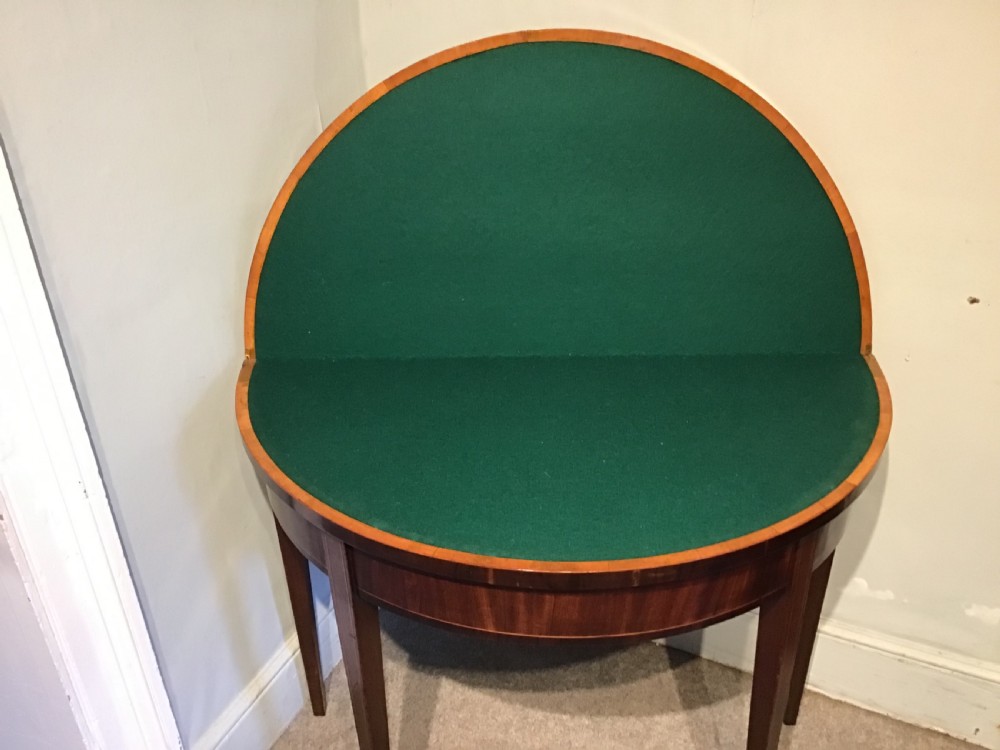 A Georgian dark mahogany demi-lune console table featuring a semicircular top with a central fan inlay motif and square tapered legs. View IX
