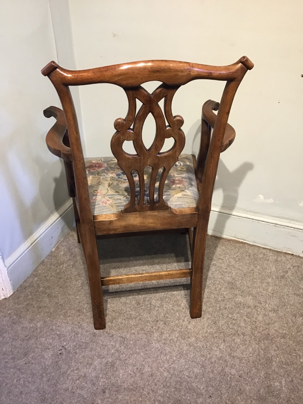 A George III mahogany elbow chair featuring a pierced scroll splat back, shaped armrests, and a multi-coloured floral tapestry drop-in seat. View III