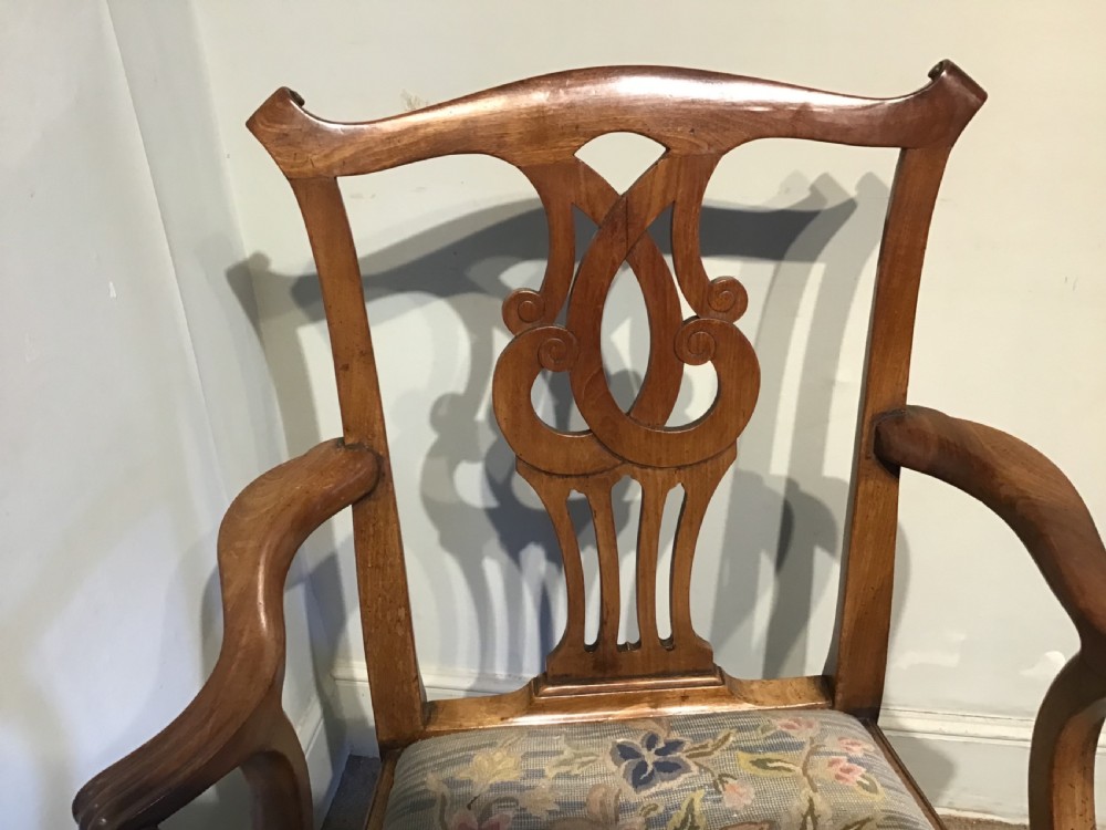 A George III mahogany elbow chair featuring a pierced scroll splat back, shaped armrests, and a multi-coloured floral tapestry drop-in seat. View IV