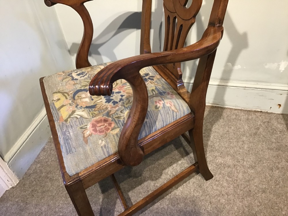 A George III mahogany elbow chair featuring a pierced scroll splat back, shaped armrests, and a multi-coloured floral tapestry drop-in seat. View V