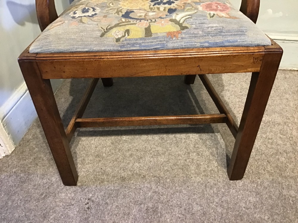 A George III mahogany elbow chair featuring a pierced scroll splat back, shaped armrests, and a multi-coloured floral tapestry drop-in seat. View VI